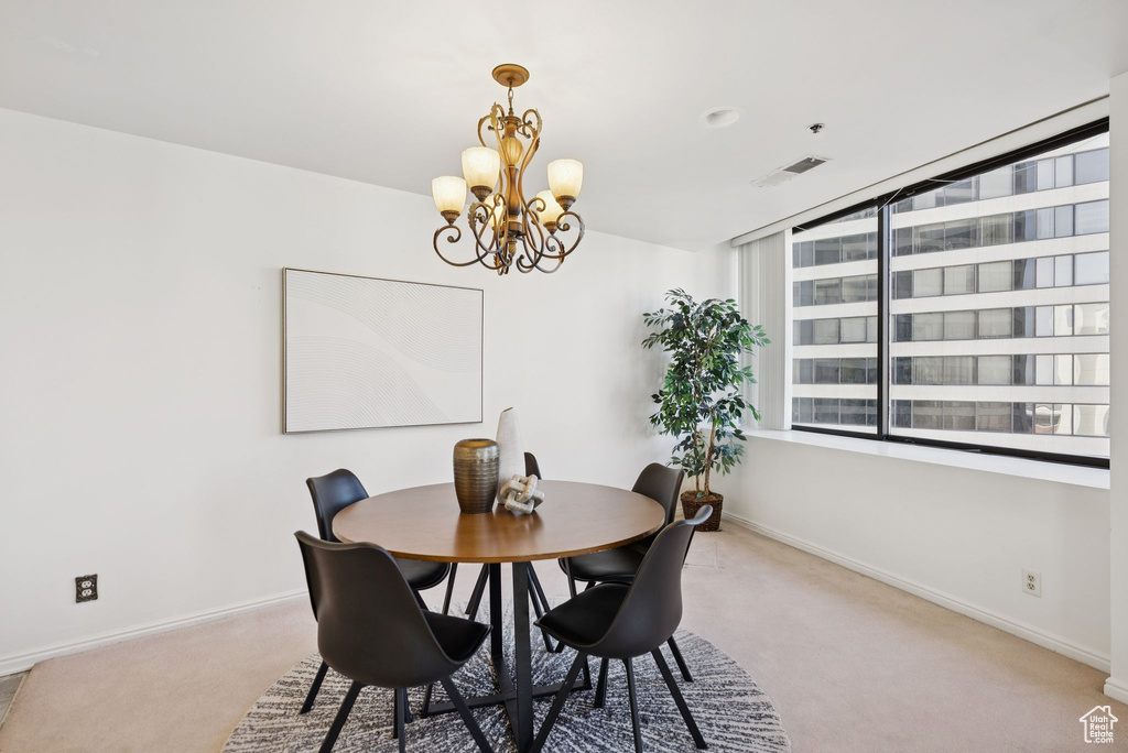 Dining area with carpet and a chandelier