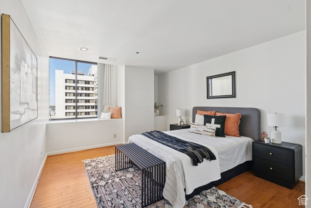 Bedroom with hardwood / wood-style floors and baseboards