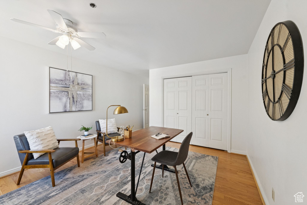 Office area with light wood-type flooring and a ceiling fan