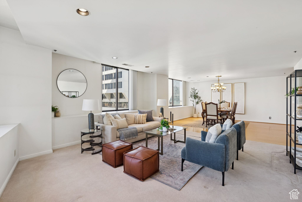 Living room with a chandelier, light carpet, and recessed lighting