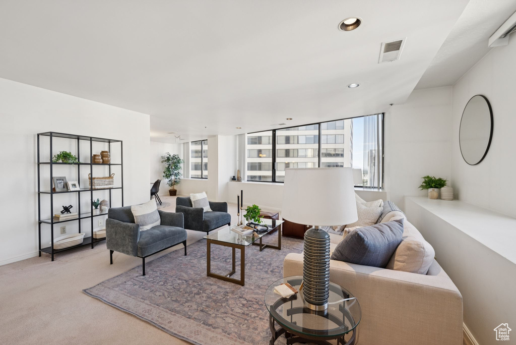 Carpeted living area with recessed lighting and baseboards