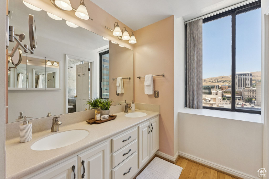 Full bath featuring wood finished floors and double vanity