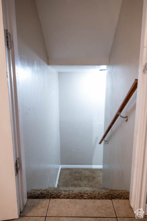 Stairs featuring lofted ceiling and tile patterned floors
