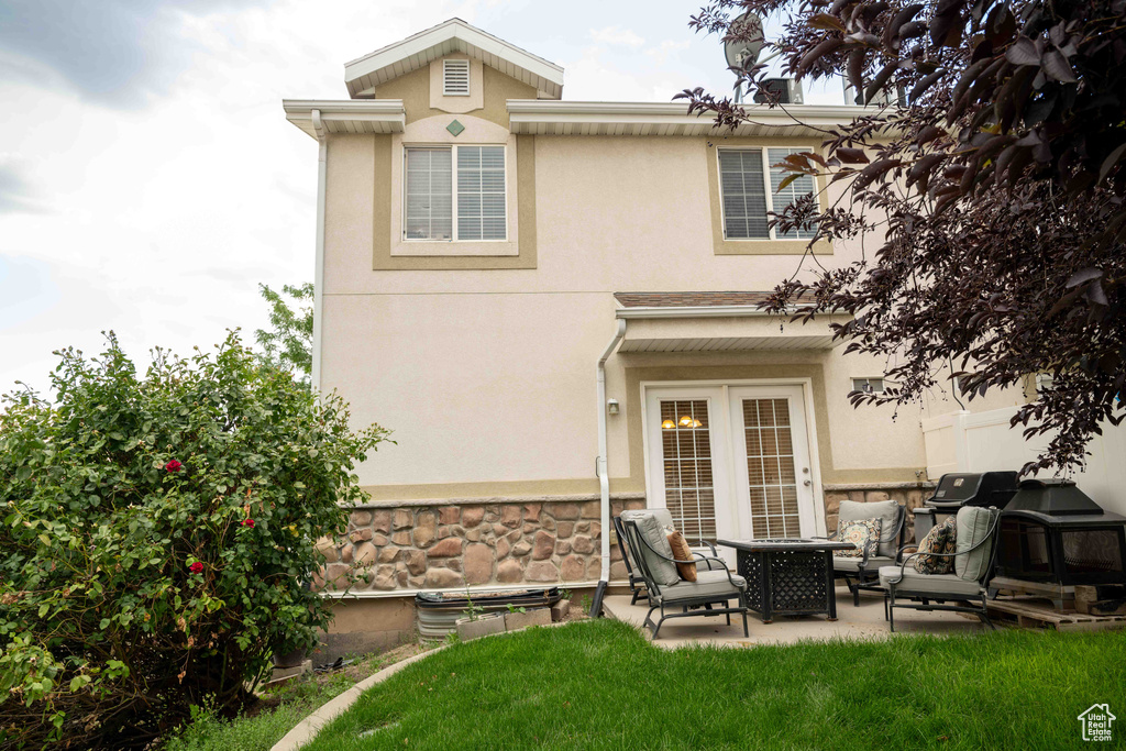 Back of property featuring stucco siding, a patio area, an outdoor hangout area, and a yard