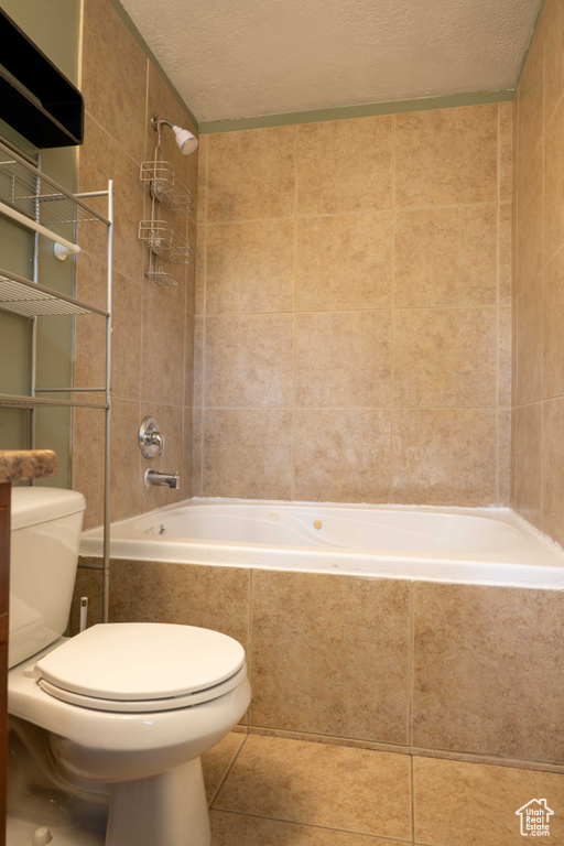 Bathroom with tiled shower / bath, tile patterned flooring, and a textured ceiling