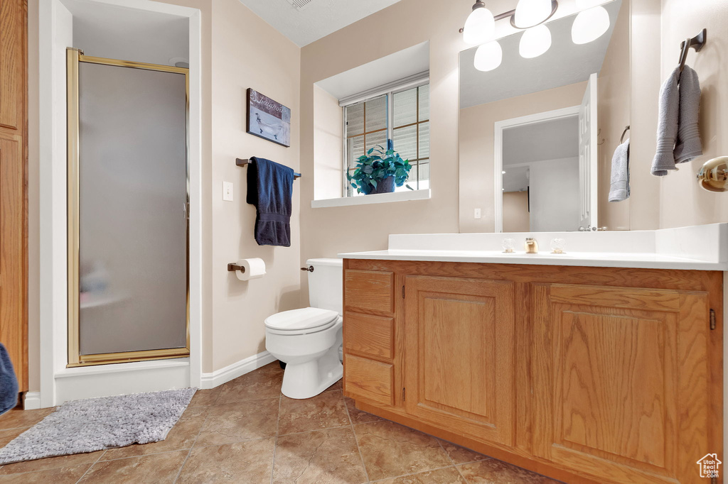 Full bathroom featuring vanity, a shower stall, and tile patterned flooring