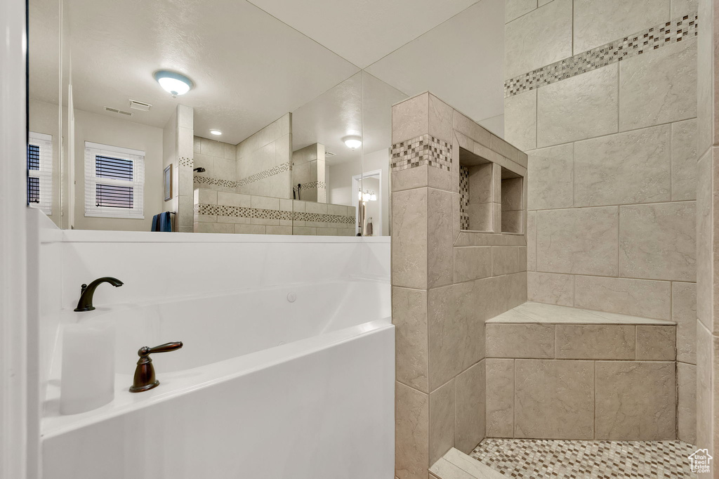 Full bath with walk in shower and a garden tub
