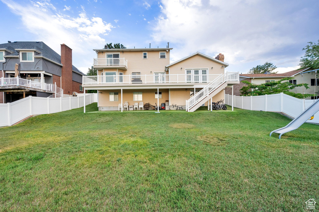 Back of property featuring a fenced backyard, stairs, and a wooden deck