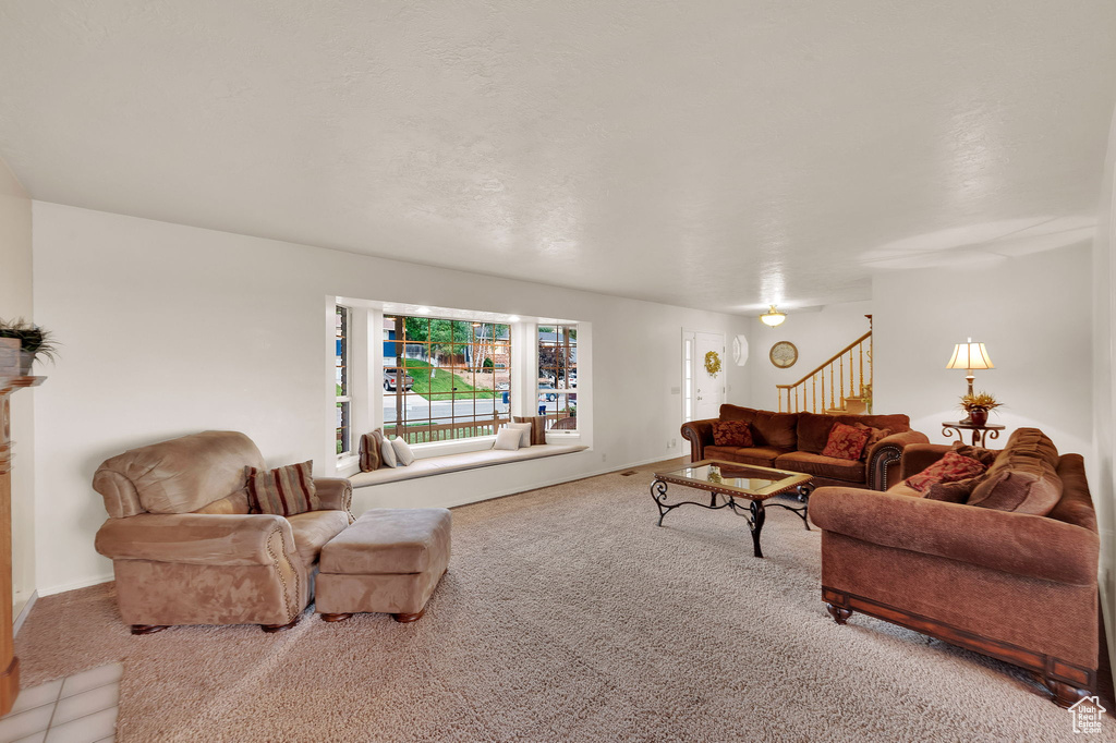 Carpeted living room featuring stairway