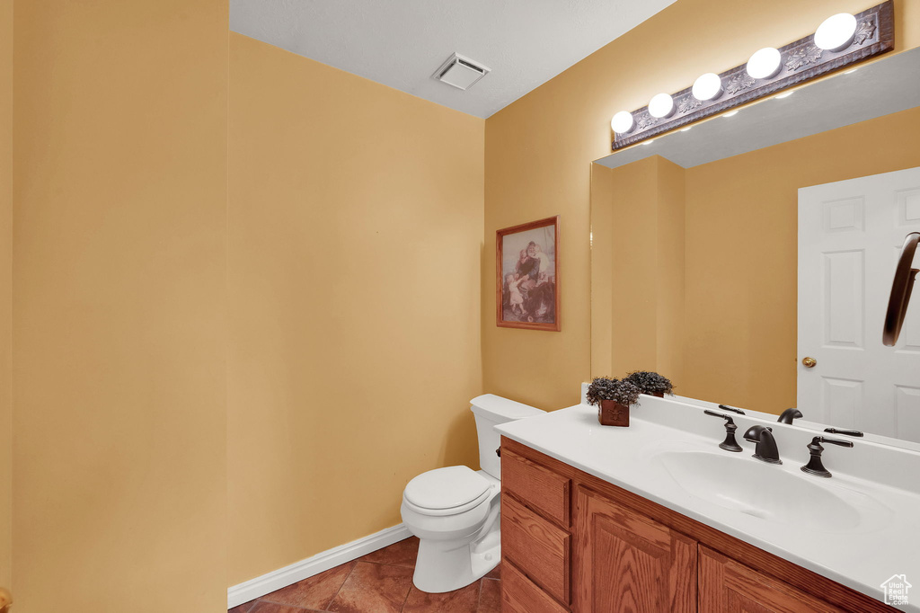 Half bathroom with vanity and tile patterned flooring