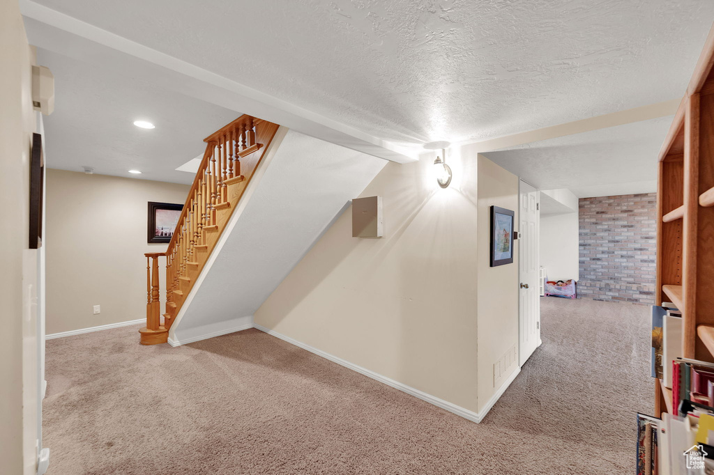 Bonus room featuring carpet, stairs, a textured ceiling, and recessed lighting