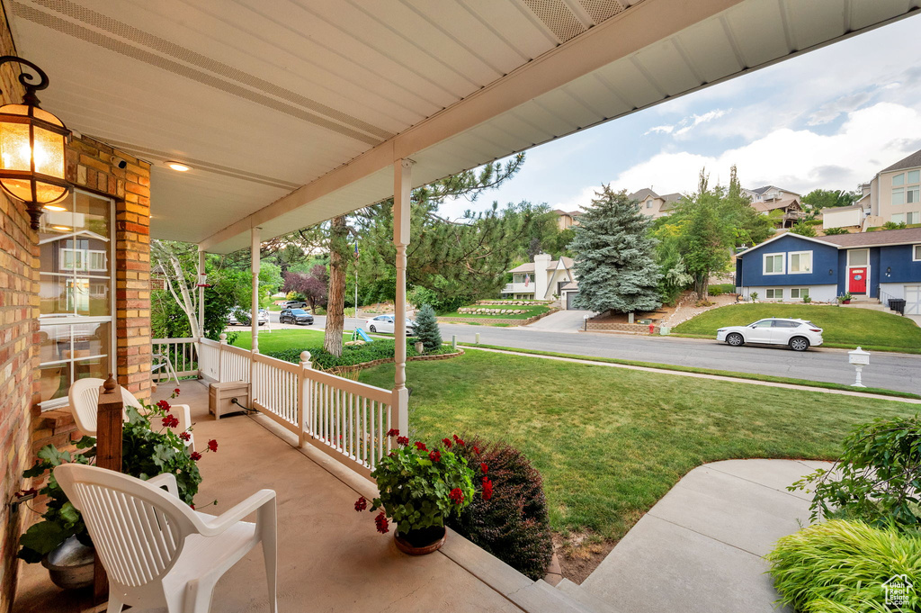 Porch featuring a residential view and a lawn