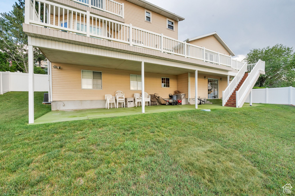 Rear view of property featuring a fenced backyard, a deck, stairway, and a patio area