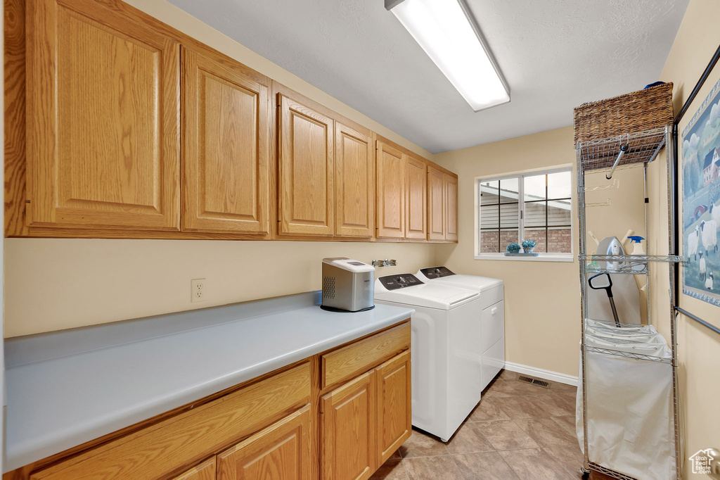 Washroom with cabinet space and washing machine and clothes dryer