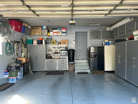 Garage featuring black refrigerator with ice dispenser
