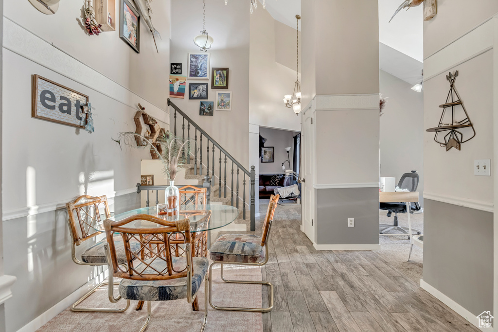 Dining area featuring a high ceiling, stairway, wood finished floors, and an office area