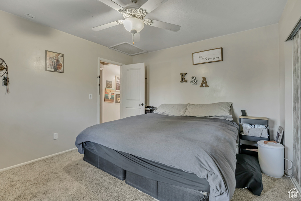 Bedroom featuring carpet flooring, a ceiling fan, and attic access