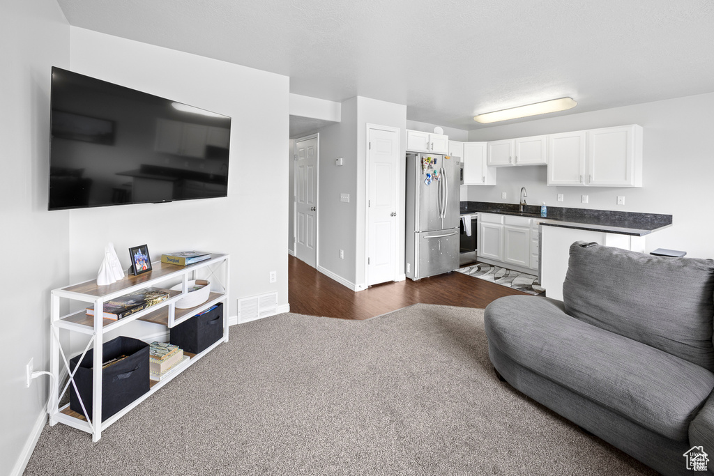 Living room with baseboards and dark carpet