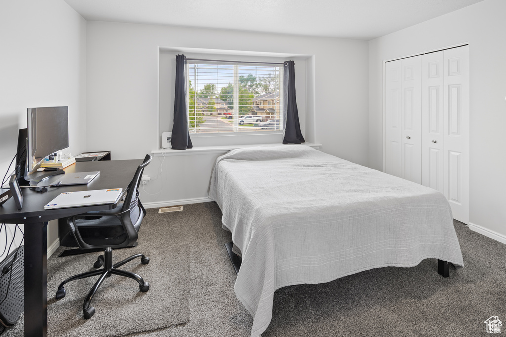 Bedroom featuring dark carpet and a closet