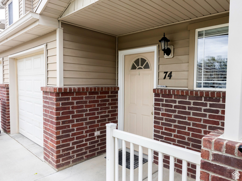 Property entrance with a garage and brick siding