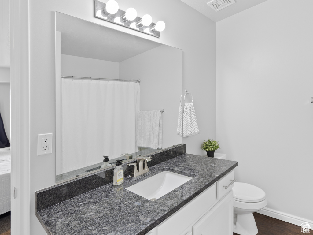 Full bath with vanity and wood finished floors