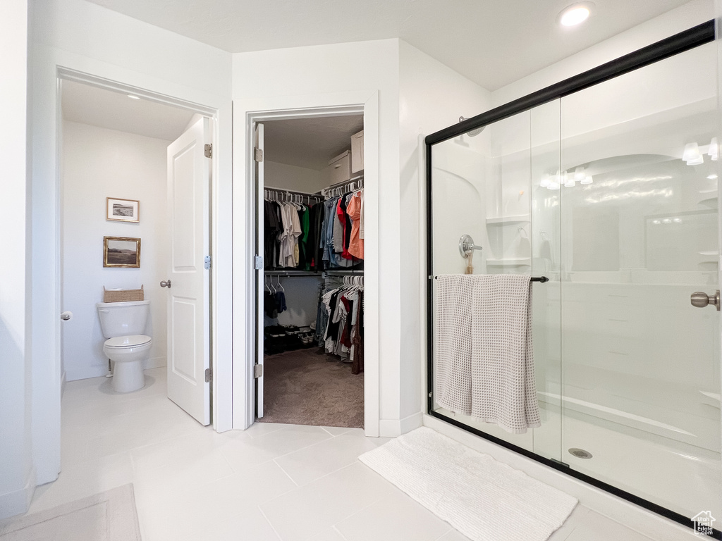 Bathroom featuring a shower stall and a walk in closet