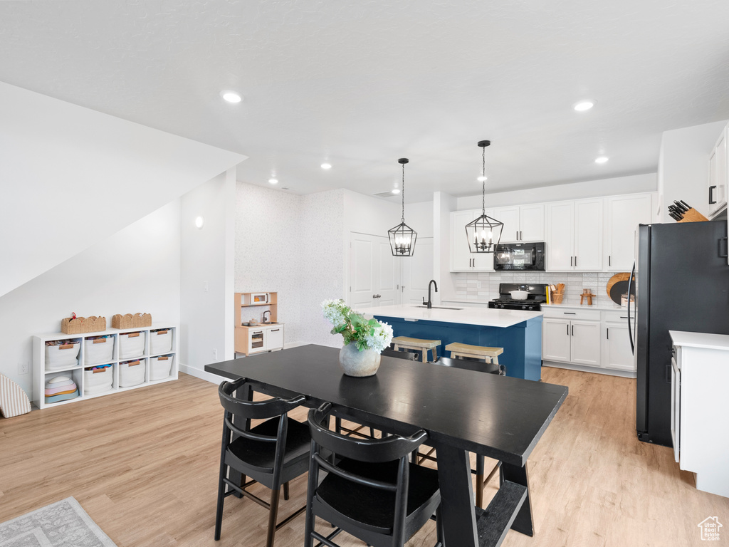 Dining space with light wood-type flooring and recessed lighting