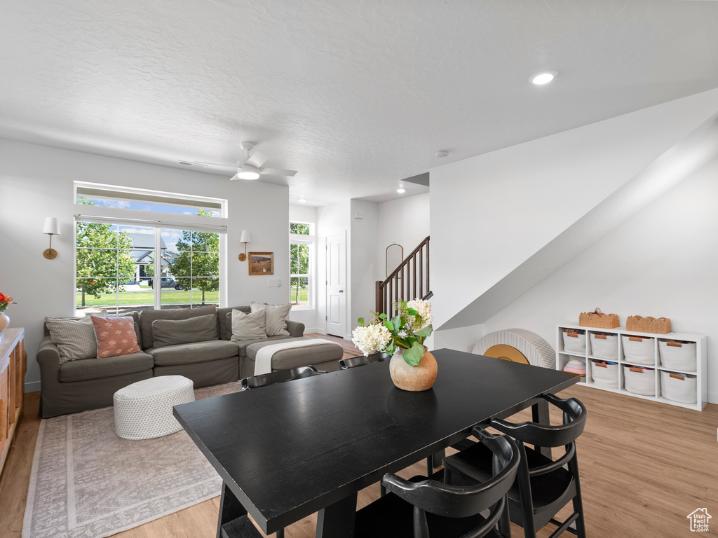 Dining space featuring light wood-style flooring, stairs, ceiling fan, and recessed lighting