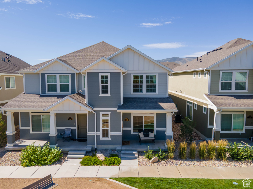 Craftsman-style home featuring covered porch, board and batten siding, and roof with shingles