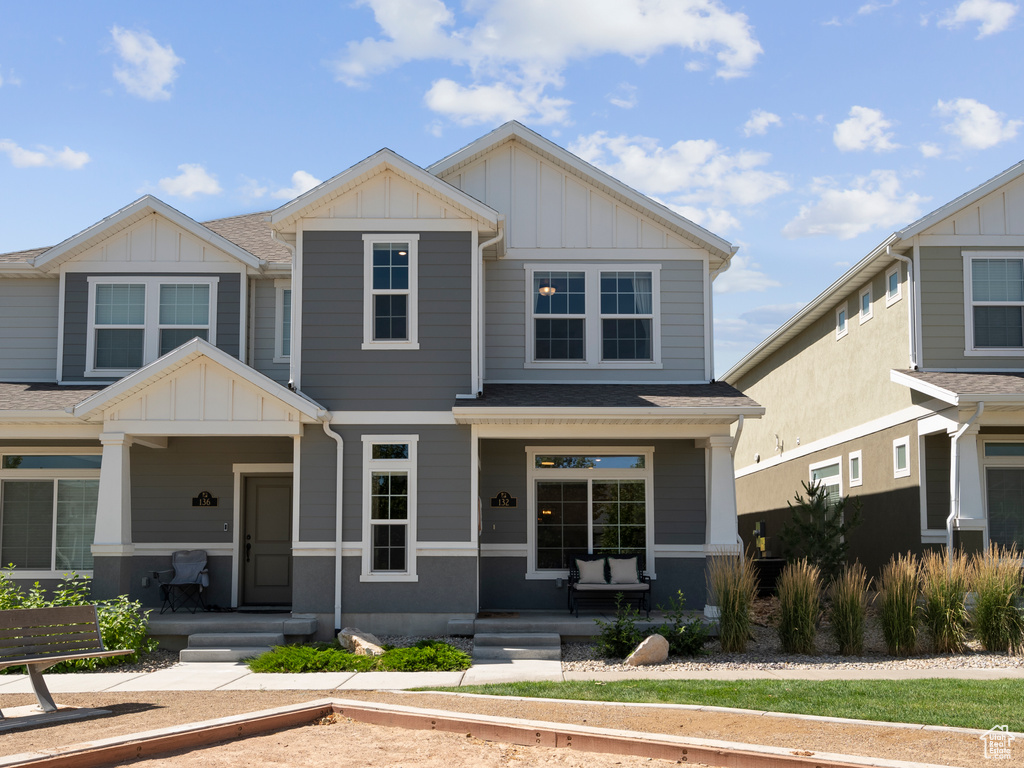 Craftsman-style home with covered porch, board and batten siding, and roof with shingles