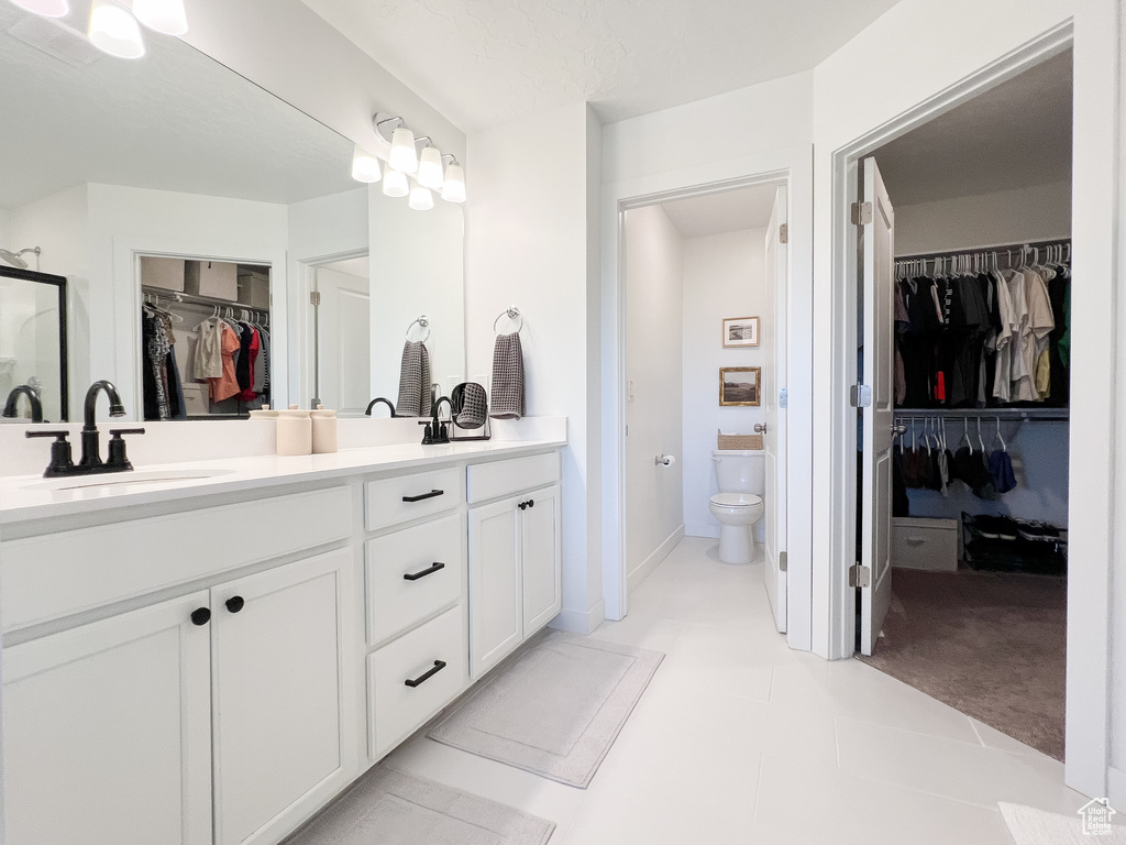 Bathroom with a walk in closet, double vanity, and a shower stall