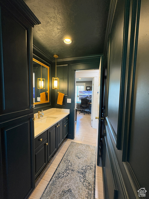 Bathroom featuring ornamental molding, vanity, a textured ceiling, and recessed lighting