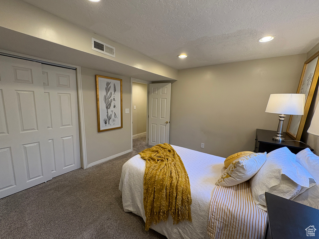 Carpeted bedroom with a textured ceiling and recessed lighting