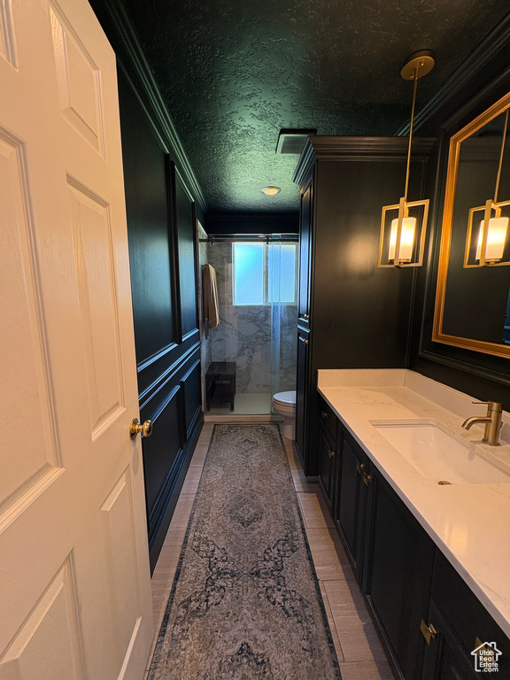 Full bathroom featuring ornamental molding, a shower stall, and vanity