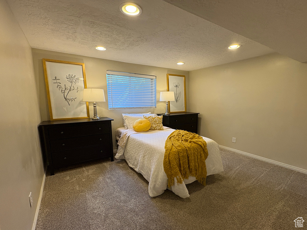 Carpeted bedroom with a textured ceiling and recessed lighting