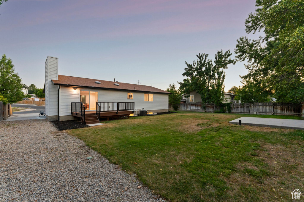 Rear view of property featuring a fenced backyard, a wooden deck, and a chimney