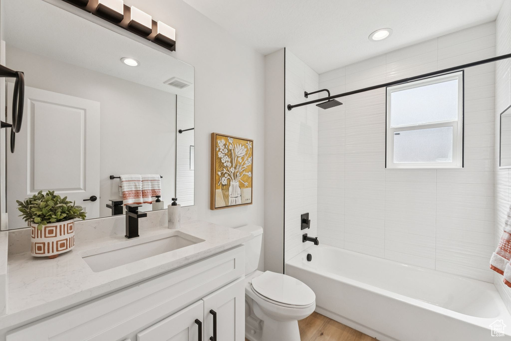 Full bathroom featuring vanity, shower / washtub combination, wood finished floors, and recessed lighting