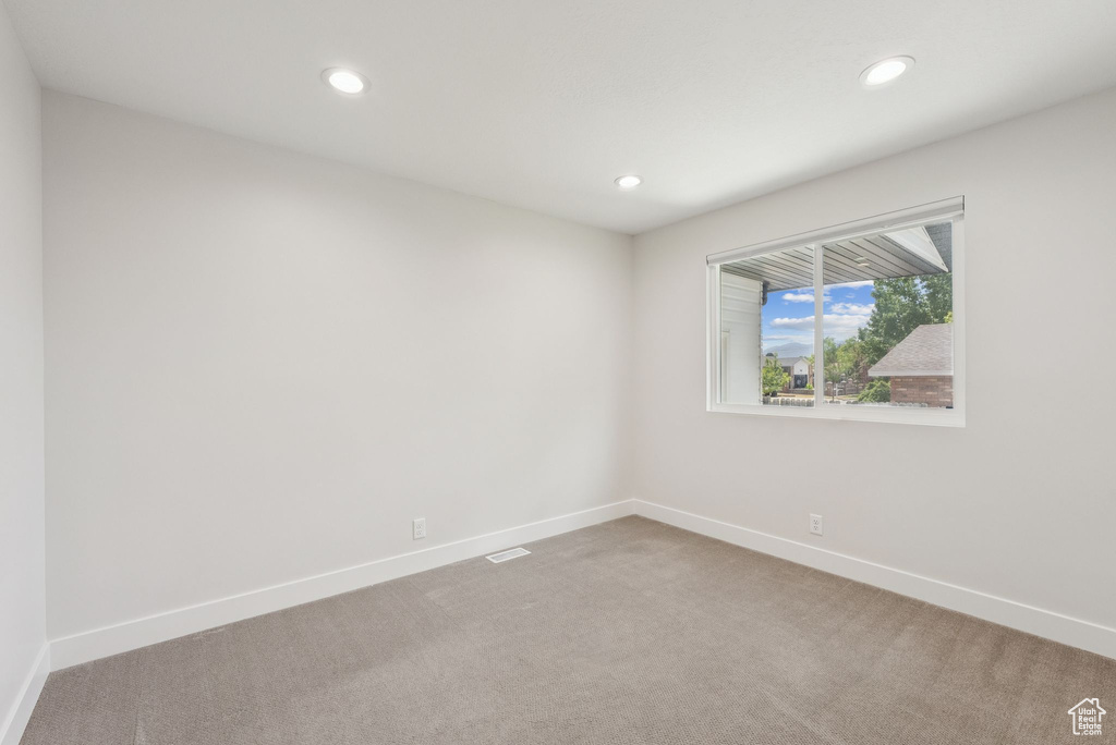 Spare room featuring light colored carpet and recessed lighting