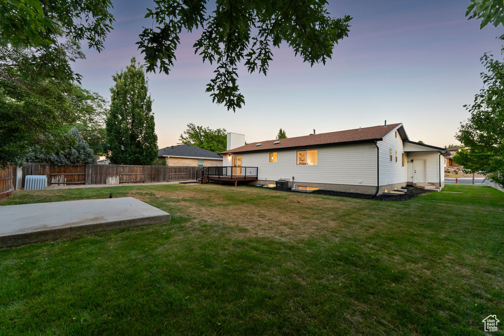 Yard at dusk featuring a deck and a patio