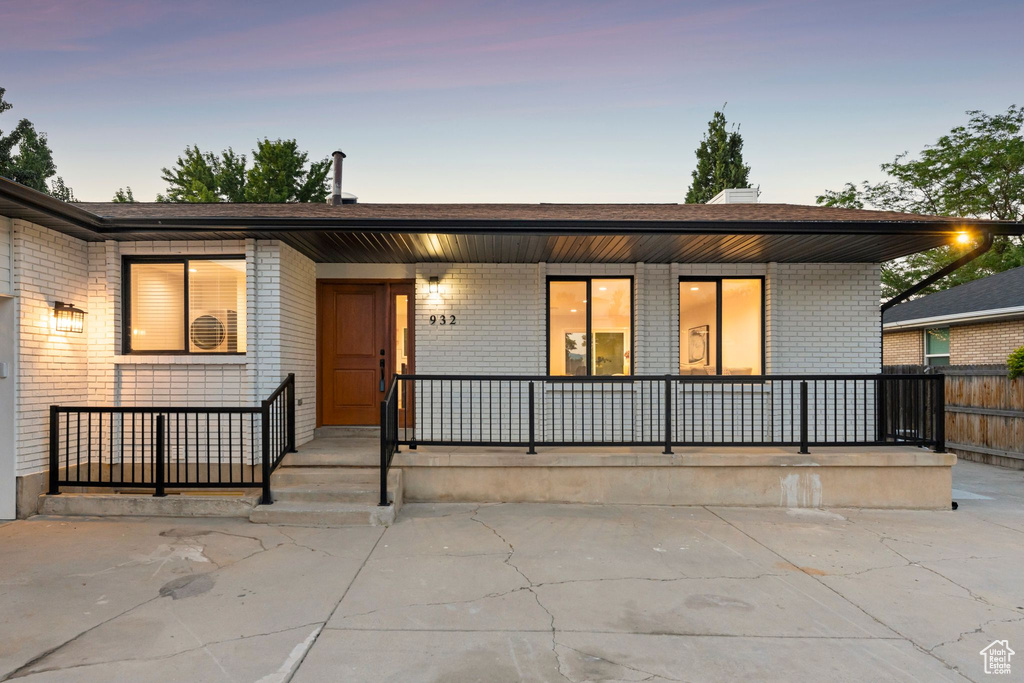 View of front of home with covered porch and brick siding