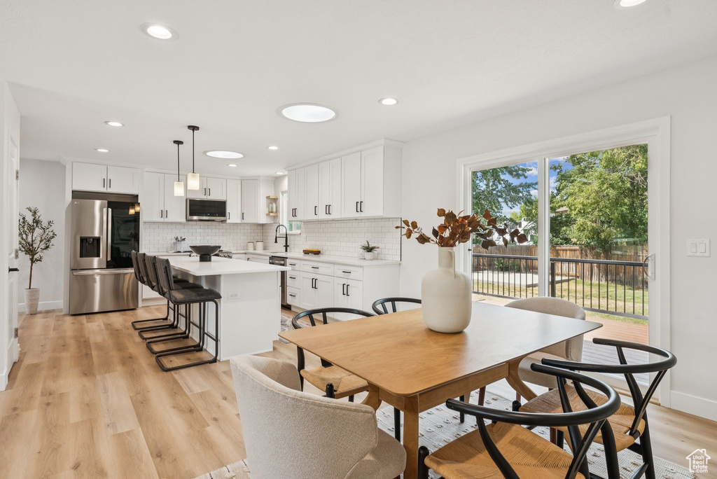 Dining room with light wood-type flooring and recessed lighting