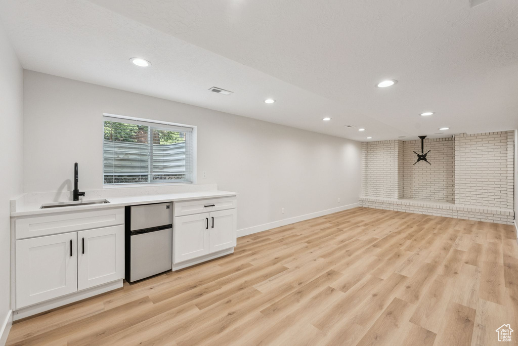 Bar area featuring refrigerator, recessed lighting, and light wood-style floors
