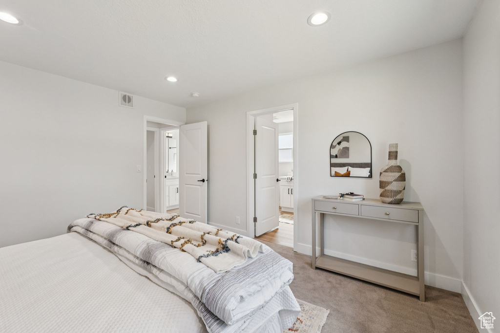 Bedroom with light carpet, recessed lighting, and ensuite bathroom