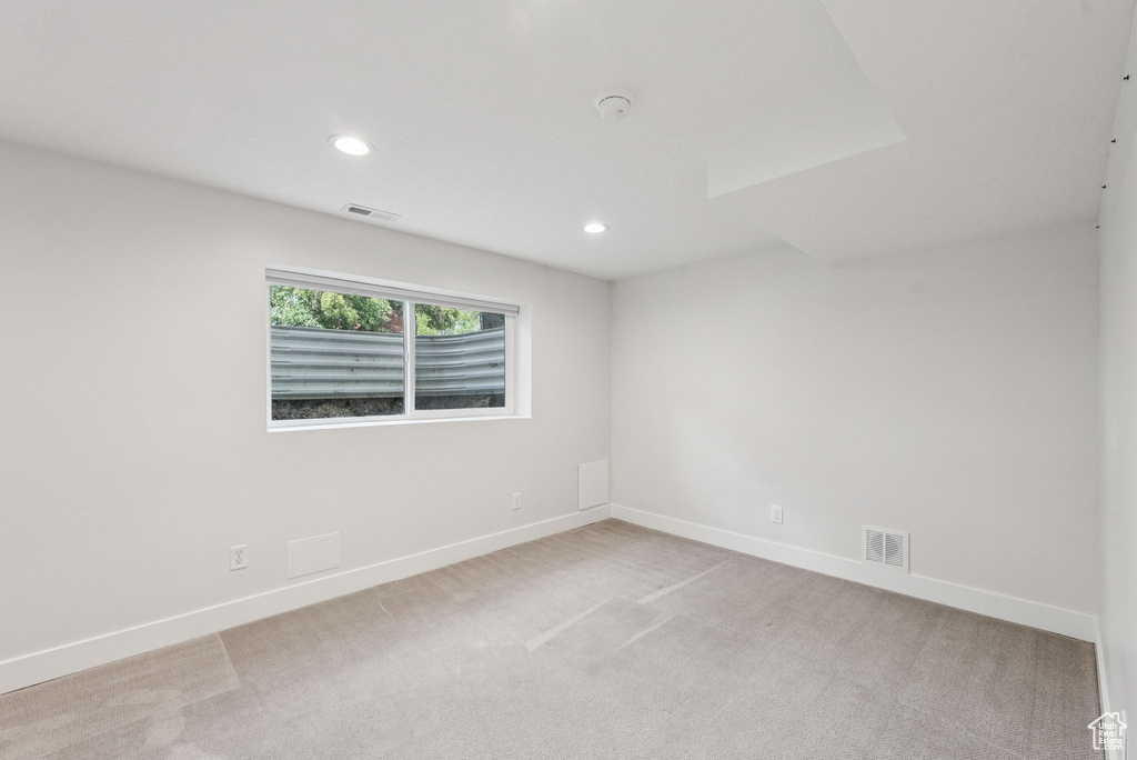 Empty room with recessed lighting, light colored carpet, and a smoke detector