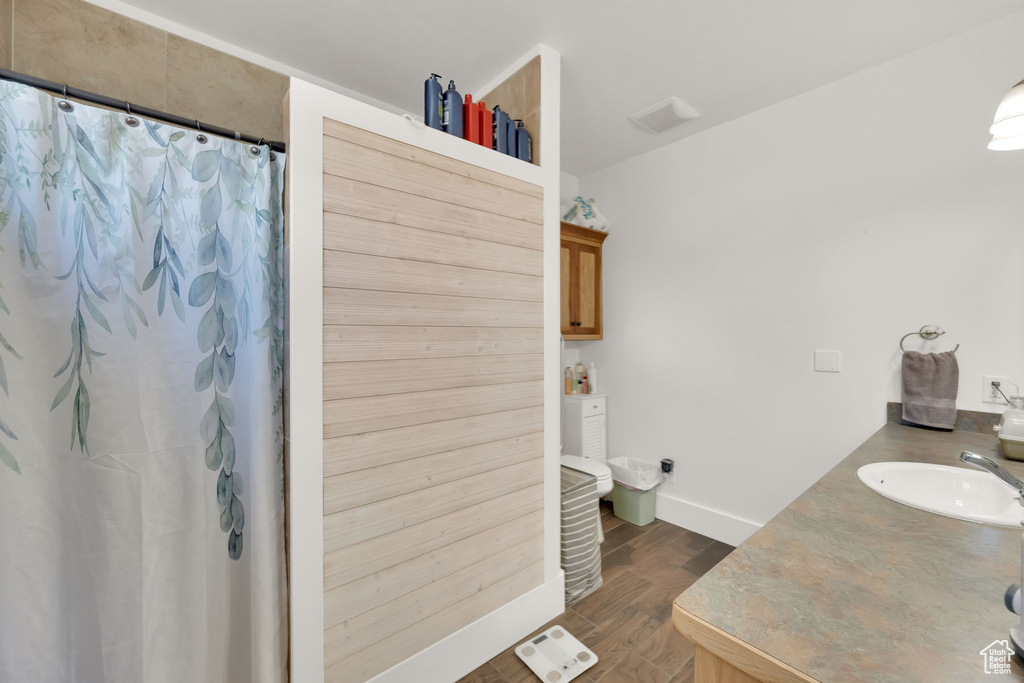Bathroom featuring wood finished floors, vanity, and curtained shower