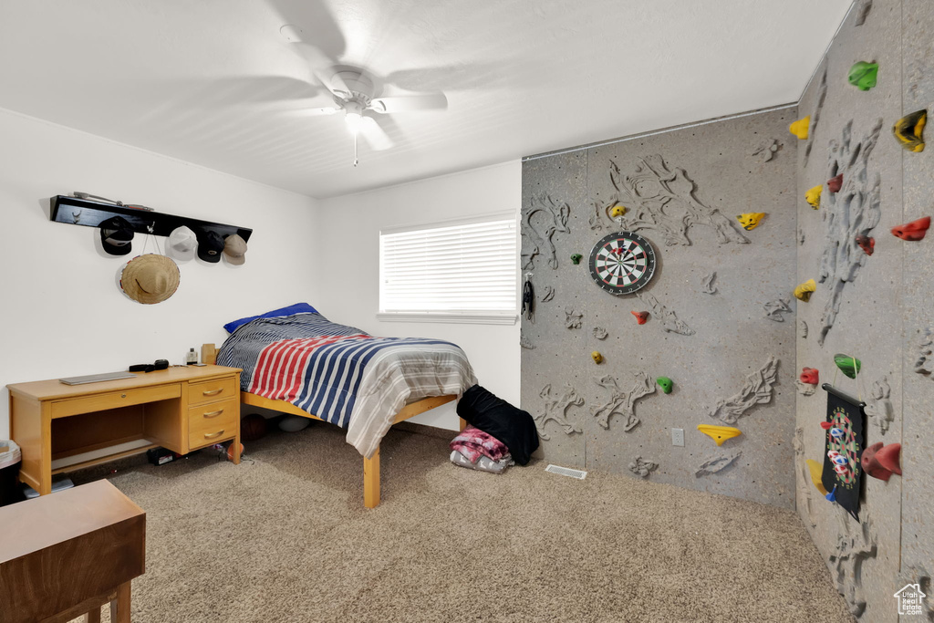 Carpeted bedroom with a ceiling fan