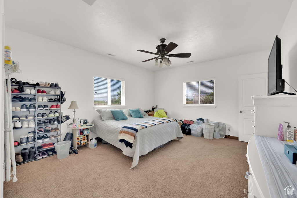 Carpeted bedroom featuring ceiling fan