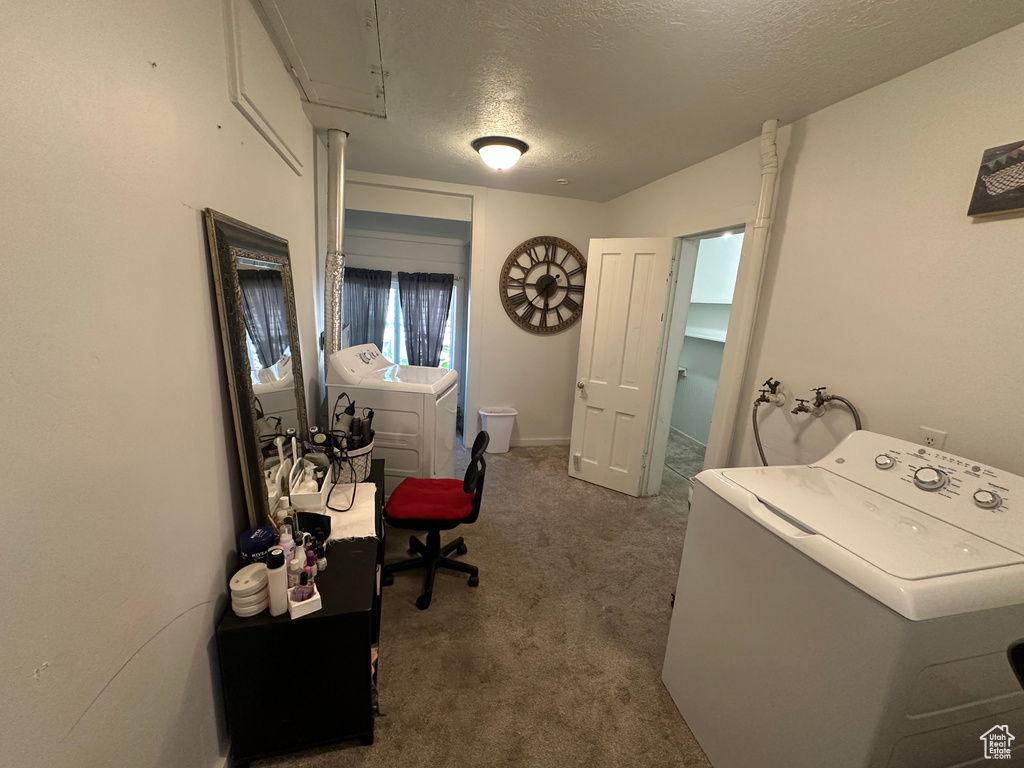 Carpeted home office with washer and dryer and a textured ceiling
