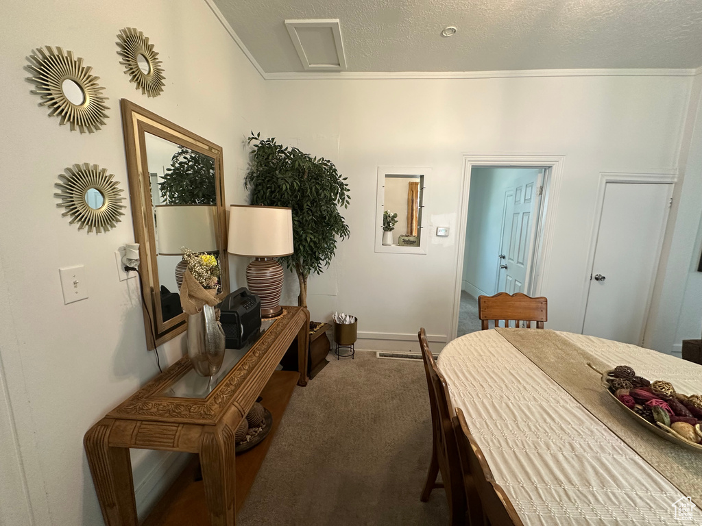 Carpeted bedroom featuring a textured ceiling and crown molding
