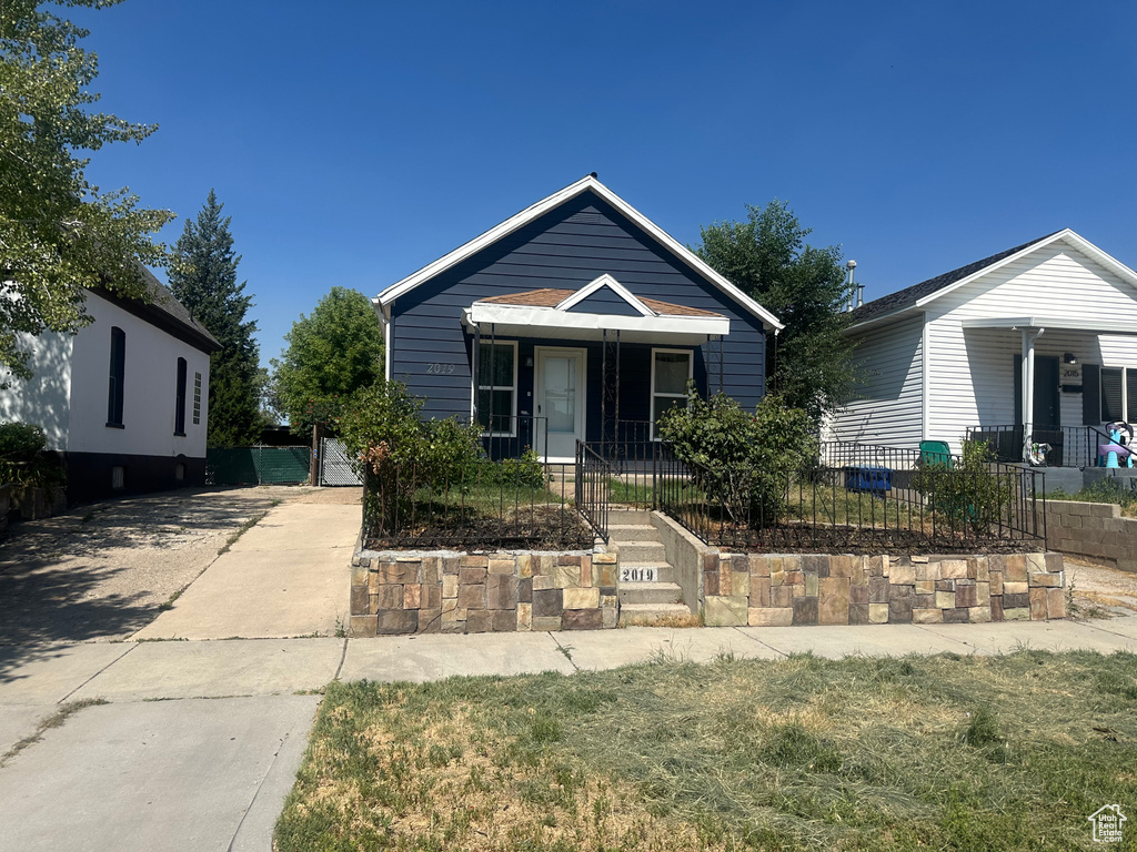 View of front of home featuring a gate, a fenced front yard, a porch, and driveway